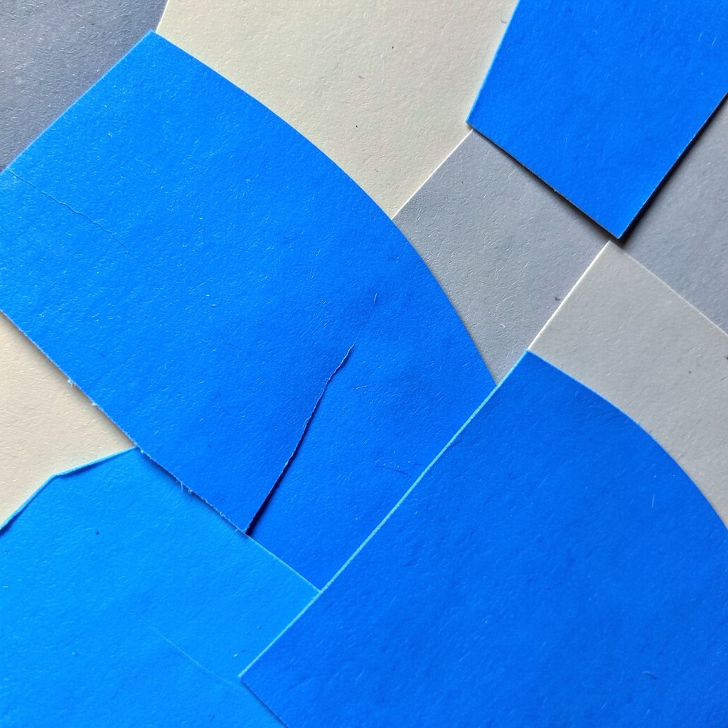 Layered paper cut-out of colorful scratch-off cards fanned out beside a mobile phone, in bright orange, magenta, and deep blue against a soft grey backdrop